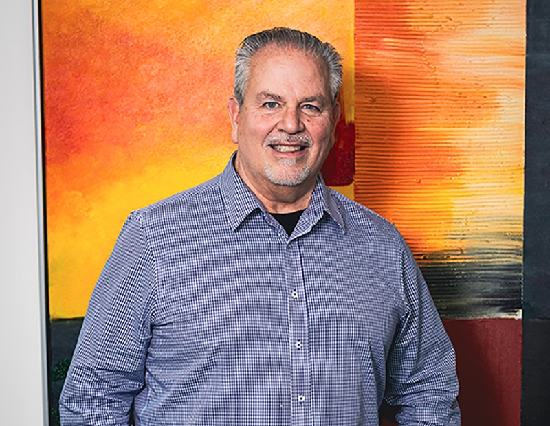 Mann vor abstraktem Gemälde im Büro von Pfreundt, einem Anbieter für mobile Wiegesysteme.