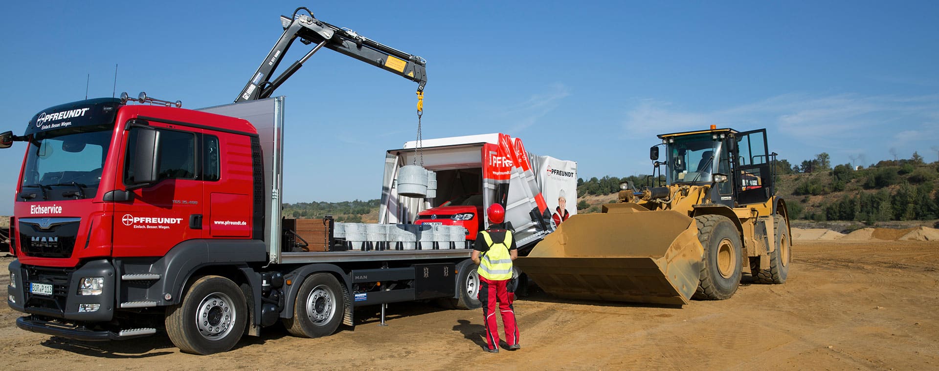 Pfreundt Lkw und Radlader bei der Arbeit mit mobilen Wiegesystemen auf einer Baustelle.