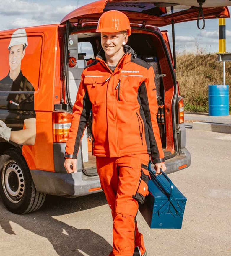 Mitarbeiter von Pfreundt mit Werkzeugkoffer vor Firmenfahrzeug; bietet mobile Wiegesysteme an.