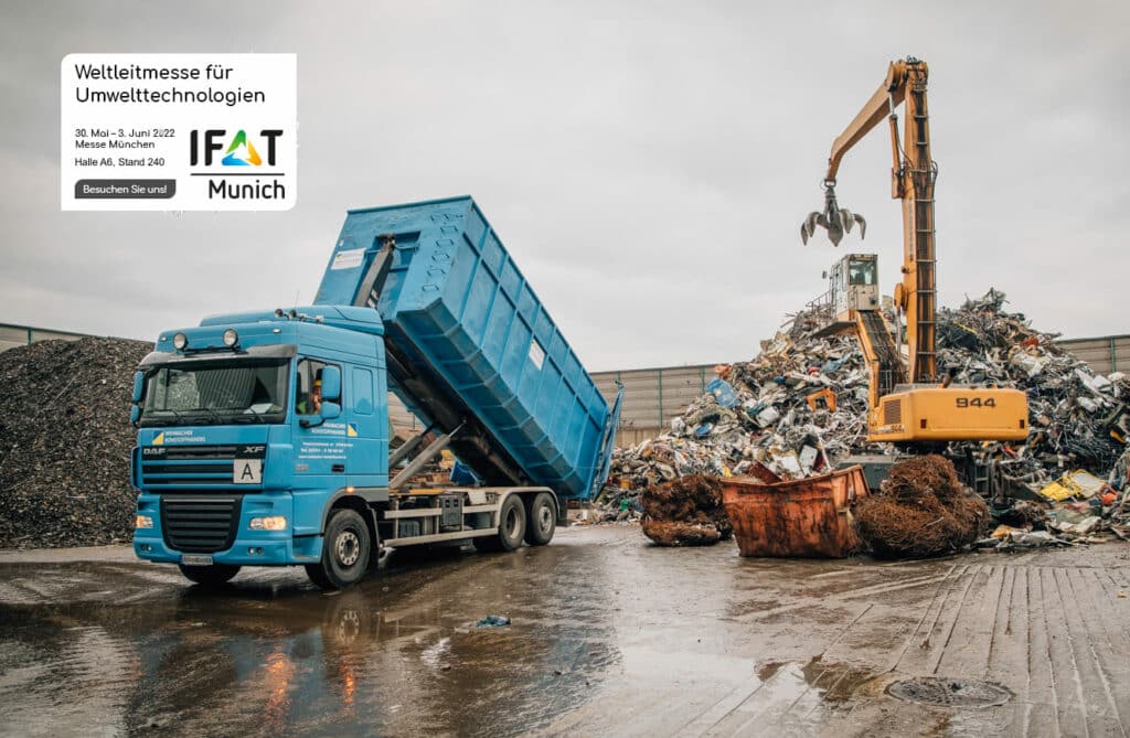 LKW kippt Entladung vor Bagger bei IFAT München, Pfreundt präsentiert mobile Wiegesysteme für Umwelttechnologien.