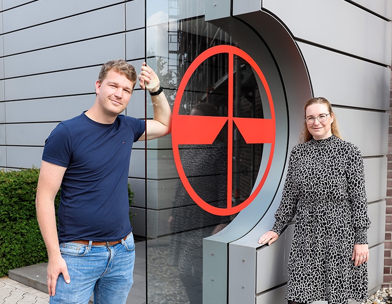 Personen vor dem Pfreundt-Logo an einem Firmengebäude. Anbieter für mobile Wiegesysteme wie Bagger- und Bandwaagen.