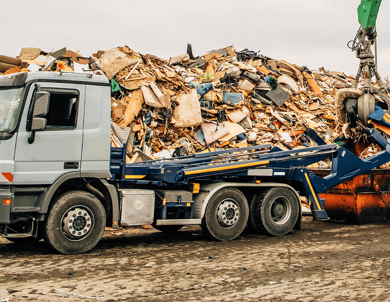 LKW mit mobilem Wiegesystem von Pfreundt vor einem Schrottplatz. Ideale Lösung für effiziente Materialverarbeitung.