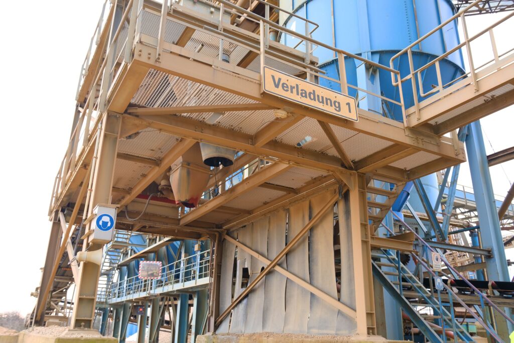 Industrieanlage mit blauem Siloturm und Schild „Verladung 1“, Teil eines mobilen Wiegesystems von Pfreundt.