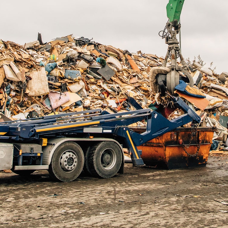 LKW lädt Schrottcontainer. Pfreundt bietet mobile Wiegesysteme für Bagger, Kräne, Radlader und mehr.