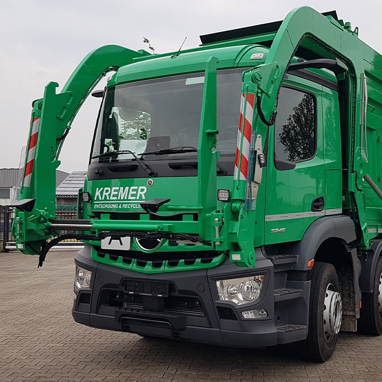 Grüner LKW von Pfreundt mit modernem mobiles Wiegesystem für effizientes Recycling und Entsorgung auf einem Betriebsgelände.