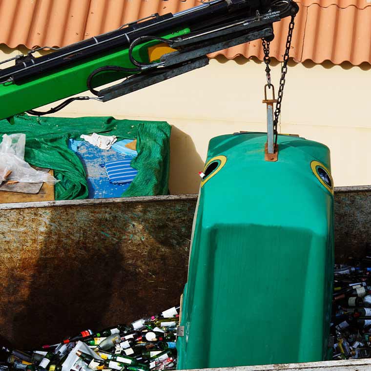 Grüner Kran hebt Container voller Flaschen an, unterstützt von Pfreundt mobilen Wiegesystemen.