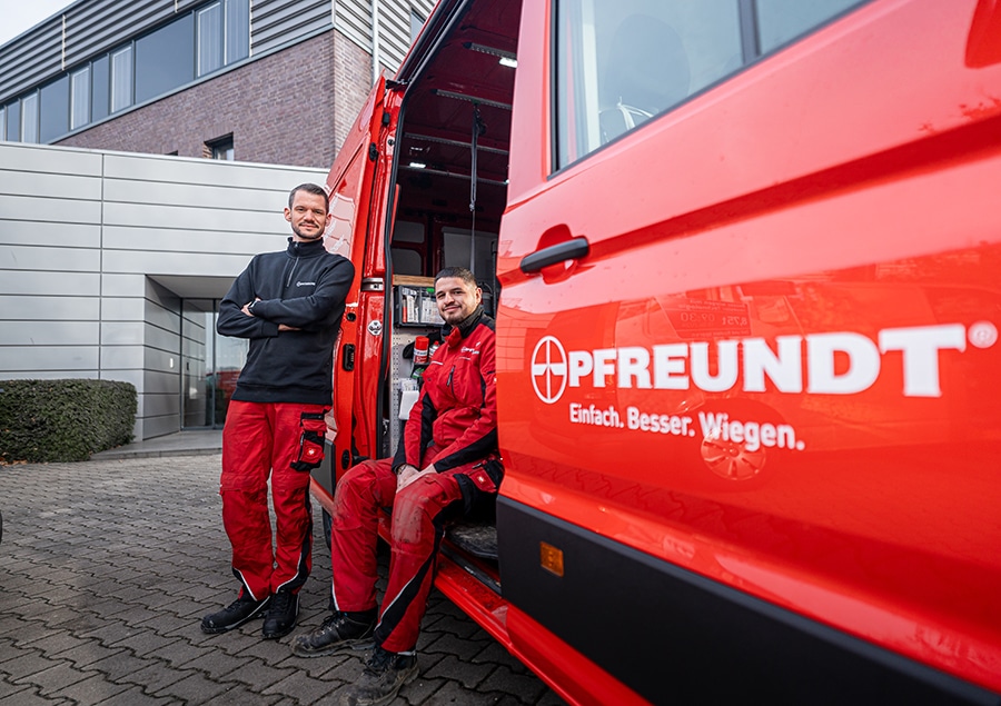 Mitarbeiter von Pfreundt neben einem Firmenwagen, spezialisiert auf mobile Wiegesysteme wie Bagger- und Kranwaagen.