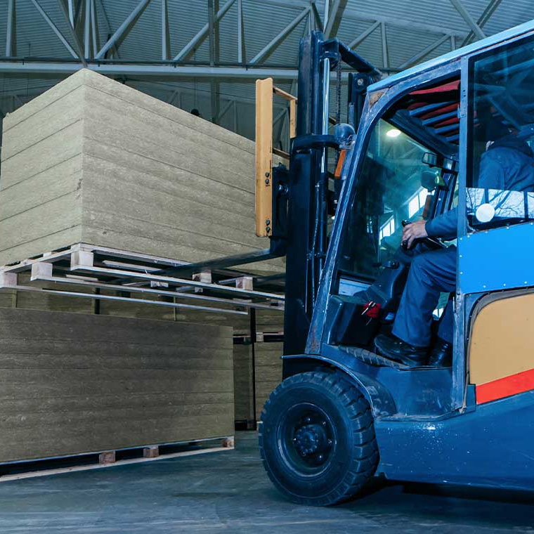 Gabelstapler transportiert Paletten in einer Lagerhalle. Pfreundt bietet mobile Wiegesysteme für präzises Beladen an.